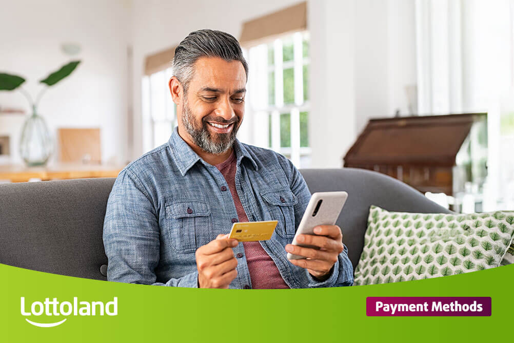 Payment Methods at Lottoland Happy man on mobile phone holding his credit card
